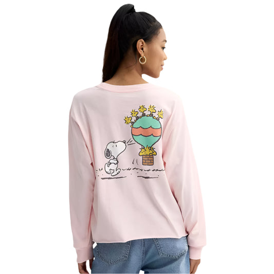 Person wearing a pink long-sleeve shirt with a cartoon design on a plain background