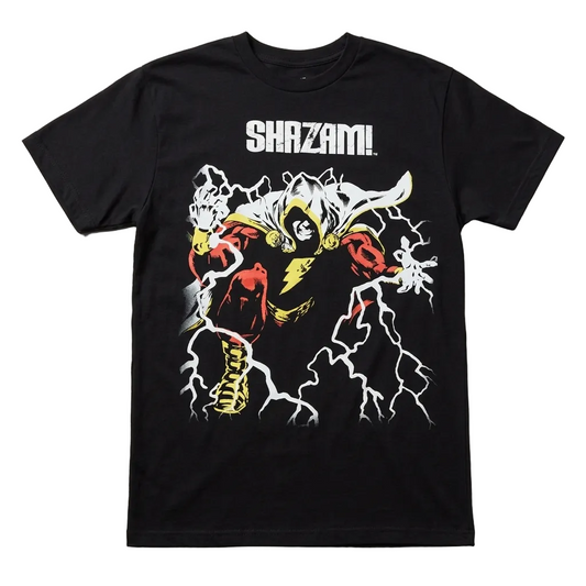A black short-sleeve graphic t-shirt featuring a stylized illustration of Shazam! in a red and yellow costume with white lightning effects, and the word 'SHAZAM!' printed in white above the graphic, laid flat on a light gray textured background.