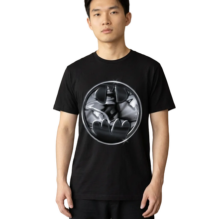 A man wearing a black short-sleeve t-shirt with a circular graphic of Batman on the chest, standing in a modern indoor setting.