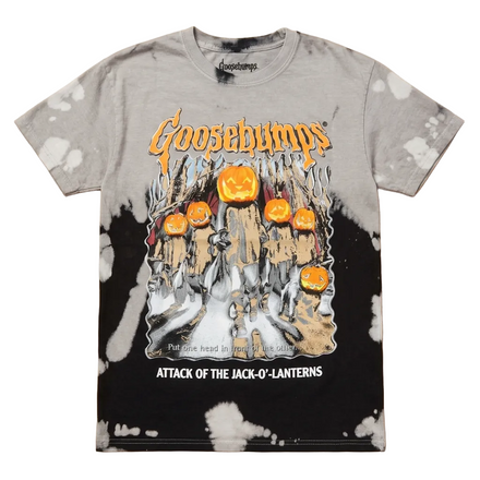 A Goosebumps graphic t-shirt featuring the 'Attack of the Jack-O-Lanterns' design, laid flat on a light wood background. The shirt has a gray and black tie-dye pattern with white splatter details, and features the Goosebumps logo and a graphic of pumpkins and a haunted house.