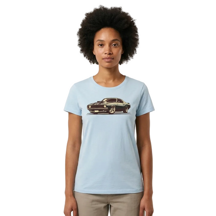A woman with an afro hairstyle wearing a light blue crewneck t-shirt with a vintage muscle car graphic on the chest, paired with beige pants, set against a plain off-white background.