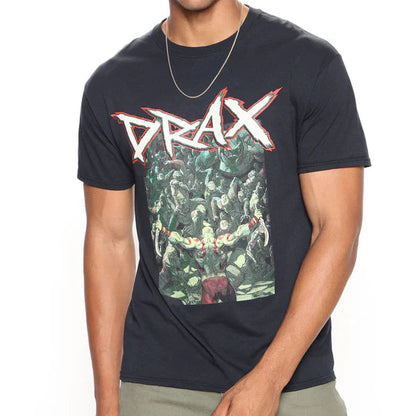 A man modeling a black graphic t-shirt featuring the word 'DRAX' in a stylized white and red font above a green and brown illustration, paired with olive green pants against a plain white background.