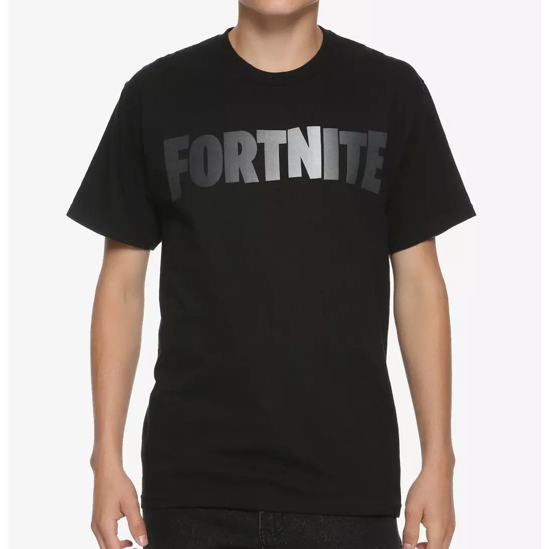 A young man wearing a black short-sleeve t-shirt with a metallic silver 'FORTNITE' logo printed across the chest, set against a plain light gray background.