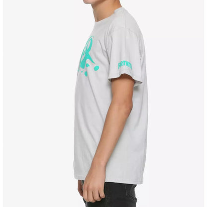 A young man wearing a light gray t-shirt with a turquoise graphic print on the front and sleeve, photographed against a plain light gray background.