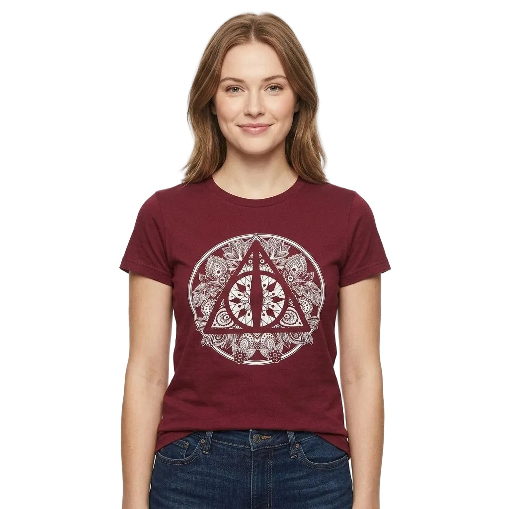 A woman wearing a maroon short-sleeve t-shirt with a circular Deathly Hallows symbol graphic on the front, paired with blue jeans, against a plain white background.