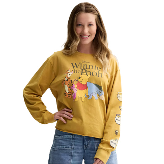 Woman wearing a yellow 'Winnie the Pooh' sweatshirt with cartoon characters on a plain background