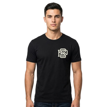 A man wearing a black short-sleeve crewneck t-shirt with a white 'NS' monogram logo on the left chest, photographed against a solid white background.