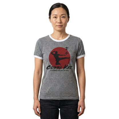 Person wearing a gray t-shirt with a 'Cobra Kai' logo on a plain background