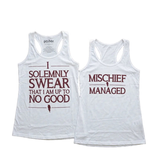 Two white tank tops with text on a wooden surface.