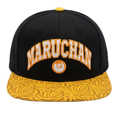 A black snapback cap with a yellow brim featuring a repeating wave pattern. The front has an arched 'MARUCHAN' logo in white with a yellow outline, and a small circular logo below it.