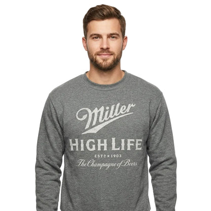 A man wearing a heather gray long-sleeve crewneck sweatshirt with a distressed white graphic print that reads 'Miller High Life' and 'The Champagne of Beer'.