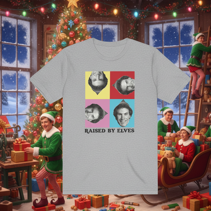 T-shirt with 'Raised by Elves' design in front of a festive Christmas scene with elves and a tree.