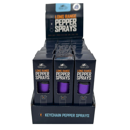 Display of long-range pepper spray keychain sprays in black packaging with purple canisters.
