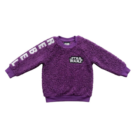 A purple sherpa fleece sweatshirt for kids, featuring 'STAR WARS' printed on the chest and 'EMBA' in white letters across the right sleeve, laid flat on a light gray concrete surface.
