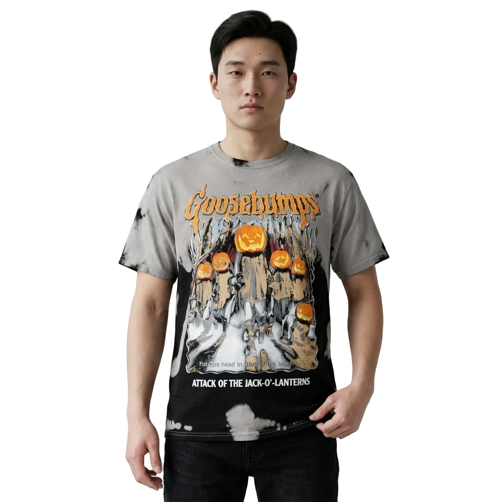 A man wearing a Goosebumps 'Attack of the Jack-O'-Lanterns' graphic t-shirt with a gray and black tie-dye wash, shown against a light gray studio background.