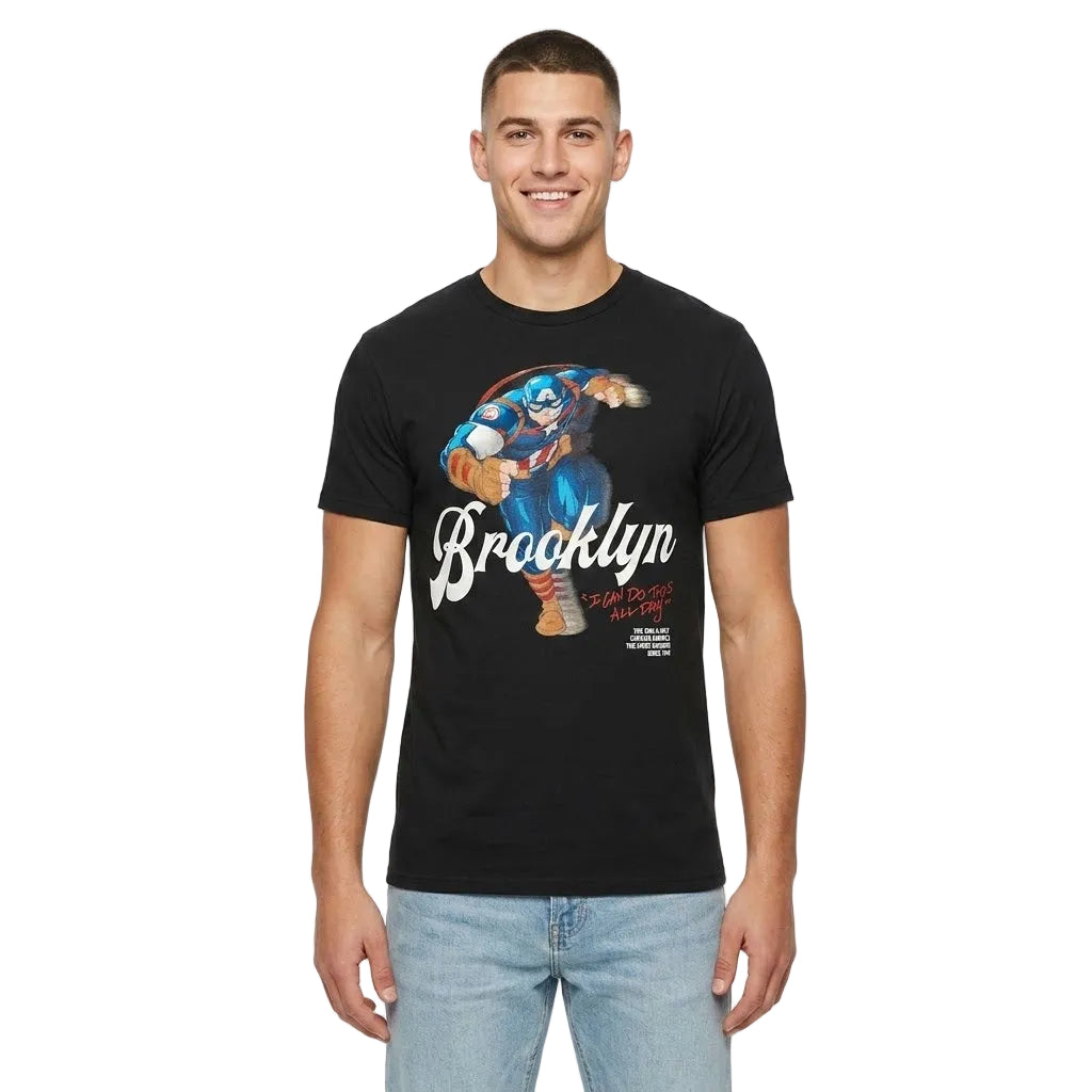 A man wearing a black short-sleeve graphic t-shirt with a colorful cartoon character and the word 'Brooklyn' printed on the front, paired with light blue jeans, against a plain white background.