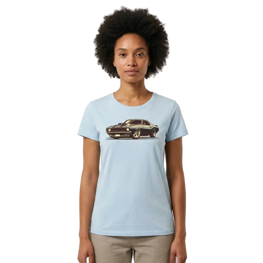 A woman with an afro hairstyle wearing a light blue crewneck t-shirt with a vintage muscle car graphic on the chest, paired with beige pants, set against a plain off-white background.