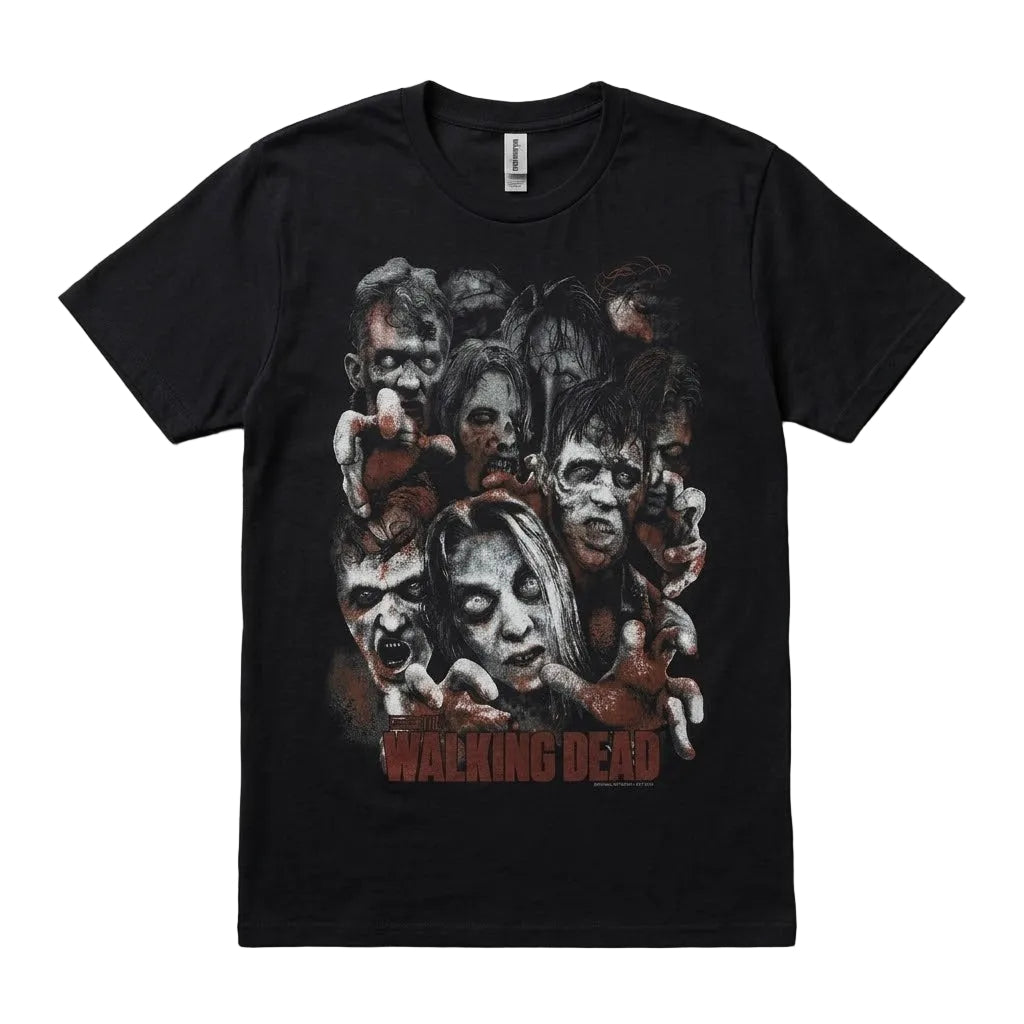 A black short-sleeve graphic t-shirt featuring a collage of zombie faces and the 'The Walking Dead' logo printed in red on the front, laid flat on a textured gray background.